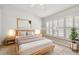 Comfortable staged bedroom featuring natural light, neutral tones, and minimalist decor at 1758 Biarritz Cir, Tarpon Springs, FL 34689