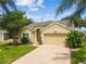 Charming home featuring lush landscaping and a brick-paved driveway at 1758 Biarritz Cir, Tarpon Springs, FL 34689