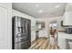 Well-lit kitchen features stainless steel appliances, wooden floor and bright white cabinetry at 1758 Biarritz Cir, Tarpon Springs, FL 34689