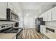Bright kitchen with white cabinetry, wood floors, stainless steel appliances, and lots of natural light at 1758 Biarritz Cir, Tarpon Springs, FL 34689