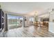 Living room with sliding glass doors to pool, light-colored wood flooring, and view of dining area at 1758 Biarritz Cir, Tarpon Springs, FL 34689