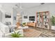Modern living room with white seating, open shelving, wood floors, and plenty of natural light at 1758 Biarritz Cir, Tarpon Springs, FL 34689