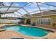 A kidney shaped pool features a screen enclosure and patio seating for outdoor enjoyment at 1758 Biarritz Cirs, Tarpon Springs, FL 34689