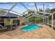 A screened in pool and brick patio area with comfortable seating and shade umbrellas at 1758 Biarritz Cir, Tarpon Springs, FL 34689