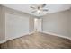 Neutral bedroom with wood-look floors, double closets, and natural light at 1890 Wateroak W Dr, Clearwater, FL 33764