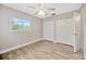 This bedroom has a large window letting in natural light, a ceiling fan, and closet at 1890 Wateroak W Dr, Clearwater, FL 33764