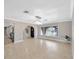 Spacious dining room with tile flooring, modern lighting, and an arched window view at 1890 Wateroak W Dr, Clearwater, FL 33764