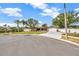 Charming one-story home featuring a spacious driveway, manicured lawn, and mature palm trees at 1890 Wateroak W Dr, Clearwater, FL 33764