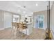 Kitchen island with seating, modern lighting, and an open layout to the living area at 1890 Wateroak W Dr, Clearwater, FL 33764