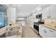Kitchen with stainless steel appliances, white cabinetry, and stone countertops at 1890 Wateroak W Dr, Clearwater, FL 33764