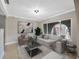 Bright living room furnished with neutral furniture, tile flooring, and a large arched window at 1890 Wateroak W Dr, Clearwater, FL 33764