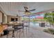 Covered patio features a bar, seating, and screened view of the pool and surrounding landscape at 1890 Wateroak W Dr, Clearwater, FL 33764