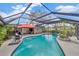 Enjoy this in-ground screened in pool with an umbrella and tropical landscaping at 1890 Wateroak W Dr, Clearwater, FL 33764
