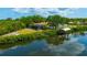 Back view of property overlooking waterfront, screen lanai, dock, and lush landscape at 1890 Wateroak W Dr, Clearwater, FL 33764