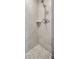 Close up on a stylish tiled shower with a built-in niche and pebble flooring at 1890 Wateroak W Dr, Clearwater, FL 33764
