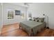 A cozy bedroom with hardwood floors, a ceiling fan, and three windows at 2009 153Rd E Ct, Bradenton, FL 34212