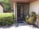 Inviting front porch with a screen door, complemented by lush greenery and decorative plants at 2025 Dover Ct, Oldsmar, FL 34677