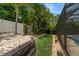 Lush backyard featuring tropical landscaping, rock gardens, and a view of a screened-in pool area at 2142 Scarlet Oaks St, Clearwater, FL 33759