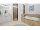 Bright bathroom featuring a soaking tub with stone surround and a glass shower at 2142 Scarlet Oaks St, Clearwater, FL 33759