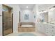 Bright bathroom featuring a soaking tub with stone surround and a glass shower at 2142 Scarlet Oaks St, Clearwater, FL 33759