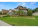 Stately home with a manicured lawn, brick driveway, and lush landscaping at 2142 Scarlet Oaks St, Clearwater, FL 33759