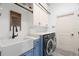 Well-equipped laundry room with a farmhouse sink, modern washer and dryer, and ample cabinet storage at 2142 Scarlet Oaks St, Clearwater, FL 33759
