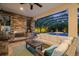 Inviting outdoor living area with stone fireplace, grill, and cozy seating overlooking the pool at 2142 Scarlet Oaks St, Clearwater, FL 33759