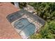 Aerial view of screened-in pool and spa with tiled deck and lush landscaping at 2142 Scarlet Oaks St, Clearwater, FL 33759