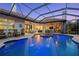 Inviting covered pool area with fountains, patio seating, and an outdoor kitchen, perfect for entertaining at 2142 Scarlet Oaks St, Clearwater, FL 33759
