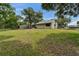 Spacious backyard with a well-kept lawn, mature trees, and rear view of the home at 23739 Forest View Dr, Land O Lakes, FL 34639
