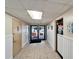 Bright hallway leading to the pool area, featuring tile flooring, wainscoting, and a clear view of outdoor amenities at 23739 Forest View Dr, Land O Lakes, FL 34639