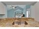 Open kitchen view into living area with vaulted ceilings, ceiling fan, and large window providing ample natural light at 23739 Forest View Dr, Land O Lakes, FL 34639