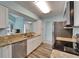 Stylish kitchen with stainless steel appliances, granite countertops, white cabinets, and a view into the living area at 23739 Forest View Dr, Land O Lakes, FL 34639