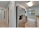 Bright kitchen with stainless steel refrigerator, white cabinets, wood-look flooring and view into adjacent dining area at 23739 Forest View Dr, Land O Lakes, FL 34639