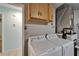Laundry room with side by side washer and dryer and overhead storage cabinets, next to utility closet at 23739 Forest View Dr, Land O Lakes, FL 34639