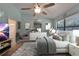 Bedroom with vaulted ceilings, ceiling fan, large windows, decorative mirror, and en-suite bathroom access at 23739 Forest View Dr, Land O Lakes, FL 34639