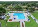 Overhead shot of a pristine swimming pool area with plenty of seating, umbrellas, and a surrounding fence at 23739 Forest View Dr, Land O Lakes, FL 34639