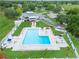 Aerial view showcasing a large community swimming pool, clubhouse, ample seating, and a beautifully landscaped area at 23739 Forest View Dr, Land O Lakes, FL 34639