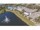 Stunning aerial view of the community with lake views, a fountain, a pool, and verdant landscaping at 2413 Oxford Down Ct # 58, Sun City Center, FL 33573