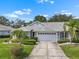 Charming single-story home features a well-manicured lawn, beautiful landscaping, and an attached two-car garage at 2413 Oxford Down Ct # 58, Sun City Center, FL 33573