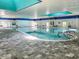 Bright indoor pool with large windows, tiled floors, and poolside seating for relaxation and recreation at 2413 Oxford Down Ct # 58, Sun City Center, FL 33573