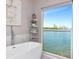 Luxurious bathroom with a freestanding tub, marble countertops, and a large window overlooking the waterfront at 2807 W Hawthorne Rd # 11, Tampa, FL 33611