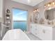 Luxurious bathroom with a freestanding tub, marble countertops, and a large window overlooking the waterfront at 2807 W Hawthorne Rd # 11, Tampa, FL 33611