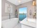 Luxurious bathroom with a freestanding tub, marble countertops, and a large window overlooking the waterfront at 2807 W Hawthorne Rd # 11, Tampa, FL 33611