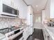 Chic modern kitchen boasts stainless steel appliances, white cabinetry, and decorative backsplash at 2807 W Hawthorne Rd # 11, Tampa, FL 33611