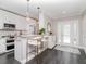 Bright kitchen with a breakfast bar, modern lighting, sleek white cabinets, and stainless steel appliances at 2807 W Hawthorne Rd # 11, Tampa, FL 33611