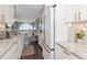 Bright kitchen featuring marble countertops, white cabinets, and stainless steel appliances with an open dining area at 2807 W Hawthorne Rd # 11, Tampa, FL 33611