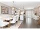 Open-concept living and dining area with white seating, modern light fixtures, and hardwood floors at 2807 W Hawthorne Rd # 11, Tampa, FL 33611