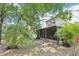 A backyard with a screened-in porch, mature trees, and tropical foliage at 330 Woods Landing Trail, Oldsmar, FL 34677