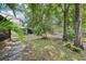 A tranquil backyard with mature trees, lush landscaping, and a glimpse of a pond at 330 Woods Landing Trail, Oldsmar, FL 34677